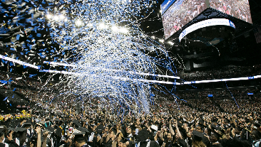Crowd at Barclays Center celebrating by throwing caps and confetti.